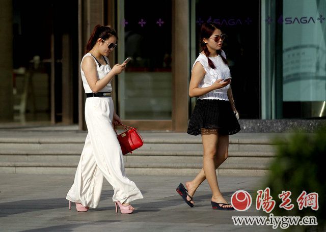 5月19日,西安小寨,美女们裙装、短裤走过街头,一派夏日风情,成为一道亮丽的风景。(梁萌摄)